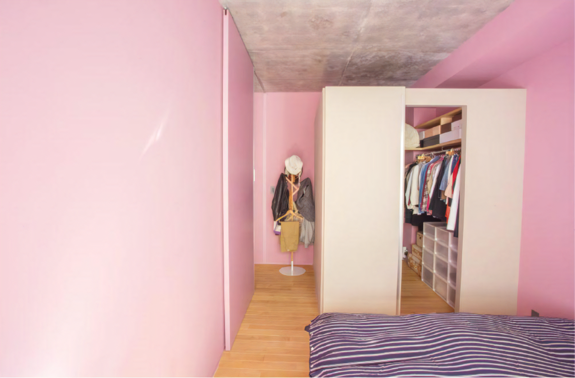 光の加減によって表情の変わる色壁の主寝室。クローゼットは湿気がこもらないよう上部を開放している。