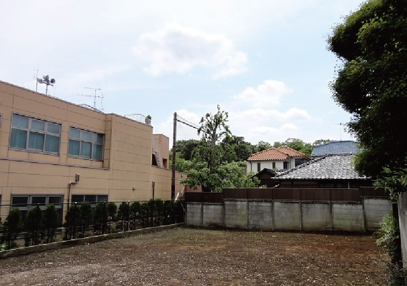 建設前の土地。児童館（写真左手）のグランドのさきに寺社の緑と空が見える。