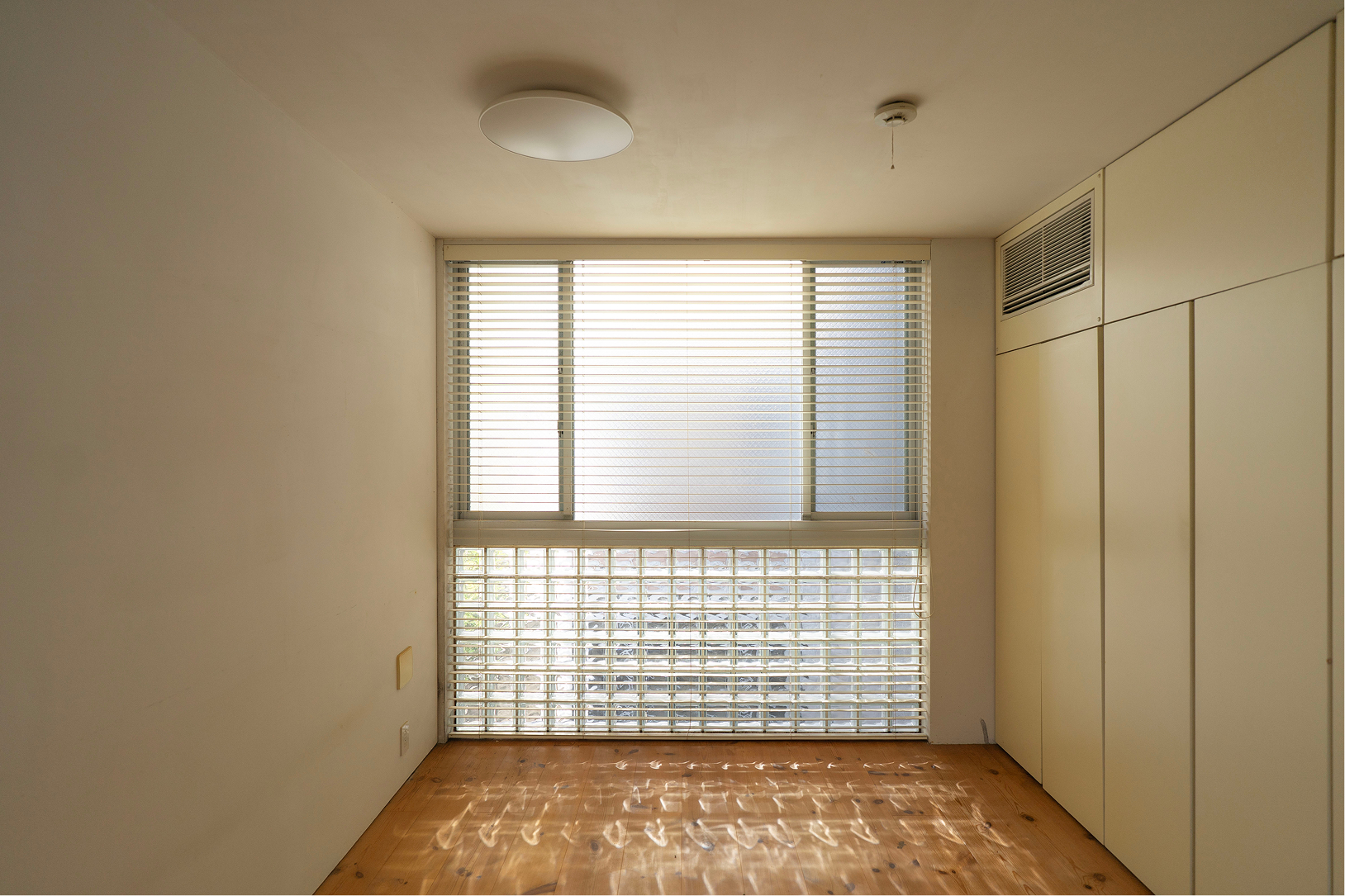 ガラスブロックの美しい光があふれる居室、たっぷりのクローゼットと目立たないよう隠蔽されたエアコン